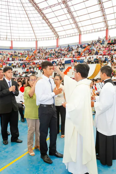 Tumbes, Tumbes, Peru 21-10-2023, Onaylama Ayini: Bir adam kalabalığın önünde bir rahip tarafından kutsanmaktadır. Rahip beyaz bir bornoz giyiyor ve kutsanan adam beyaz bir gömlek giyiyor.