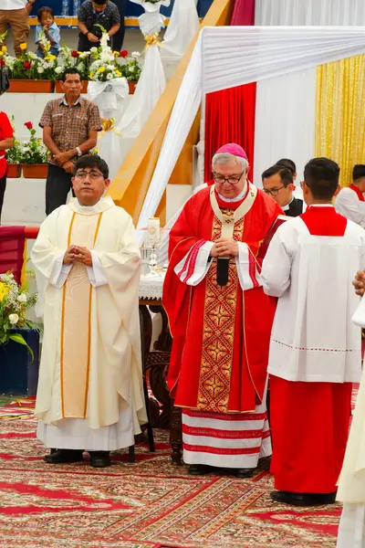 Tumbes, Tumbes, Peru 21-10-2023, Doğrulama Ayini: Kırmızı ve beyaz cüppeli bir grup insan bir masanın etrafında toplandı. Adamlardan biri rahip.