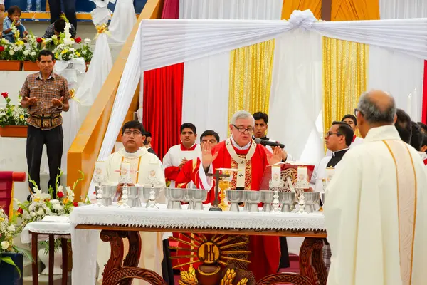 Tumbes, Tumbes, Peru 21-10-2023, Onaylama Ayini: Bir rahip bir grup mumla bir masanın önünde duruyor ve etrafında bir grup insan duruyor.