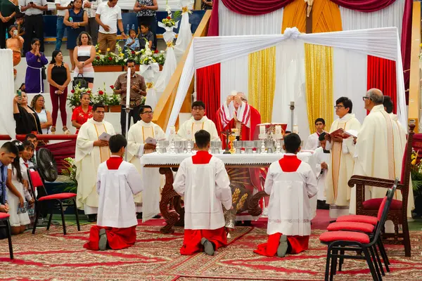 Tumbes, Tumbes, Peru 21-10-2023, Doğrulama Ayini: Kırmızı ve beyaz cüppeli bir grup adam bir masada diz çöküyor. Beyaz ve kırmızı bornozlar giyiyorlar ve yerde diz çöküyorlar.