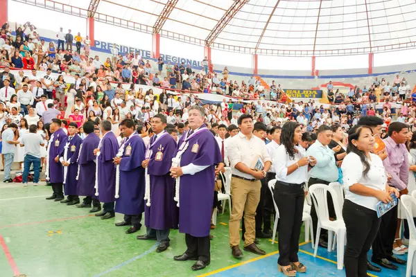 Tumbes, Tumbes, Peru 21-10-2023, Onaylama Ayini: Bir grup insan stadyumda duruyor, bazıları mor cübbe giyiyor. Dini bir törene ya da etkinliğe katılma ihtimalleri olduğu için atmosfer ciddi ve odaklanmış durumda.