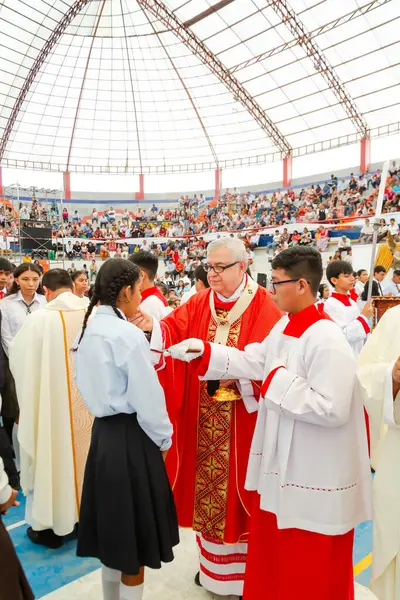 Tumbes, Tumbes, Peru 21-10-2023, Doğrulama Ayini: Bir rahip genç bir kızı kutsuyor. Rahip kırmızı bir bornoz giyiyor ve kız mavi bir gömlek giyiyor. Rahibin elinde beyaz bir mendil var.
