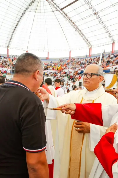 Tumbes, Tumbes, Peru 21-10-2023, Doğrulama Ayini: Bir rahip siyah gömlekli bir adamı kutsuyor. Rahip kırmızı bornoz ve beyaz yaka giyiyor.