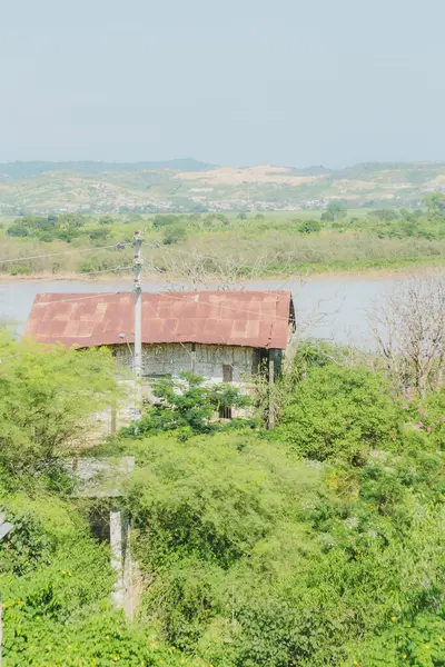 Bir kır kulübesi yemyeşil bir ormanda bulunur. Kulübe ağaçlar ve bir nehirle çevrilidir. Sahne huzurlu ve huzurlu, kamara doğal ortama uyum sağlıyor.