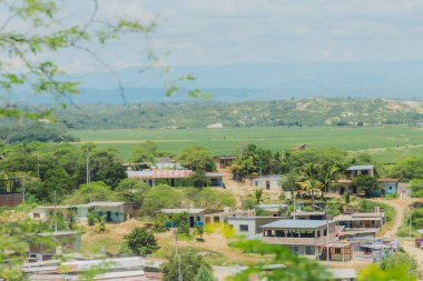 Ev ve ağaçların karışımından oluşan kırsal bir kasaba. Evler küçük ve bazıları çatıya sahip olmak üzere tüm bölgeye dağılmış durumda. Ağaçlar yeşil ve yayılmış.