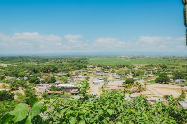 Uzakta küçük bir kasabası olan kırsal bir bölge. Gökyüzü açık ve mavi. Kasaba yemyeşil bir tarla ile çevrili.