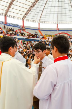 Tumbes, Tumbes, Peru 21-10-2023, Onaylama Ayini: Bir rahip bir grup insanı kutsuyor. Rahip beyaz bir bornoz giyiyor ve insanlar beyaz gömlek giyiyor.