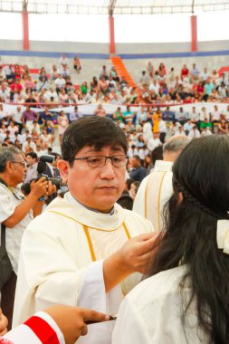 Tumbes, Tumbes, Peru 21-10-2023, Doğrulama Ayini: Beyaz cüppeli bir adam bir kadının saçını kesiyor. Adam beyaz bir bornoz ve gözlük takıyor. Kadın saçını bir erkeğe kestiriyor.