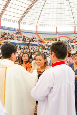 Tumbes, Tumbes, Peru 21-10-2023, Doğrulama Ayini: Bir rahip kalabalıkta bir kadını kutsuyor. Rahip beyaz bir bornoz giyiyor ve kadın siyah bir elbise giyiyor. Kalabalık töreni izliyor.