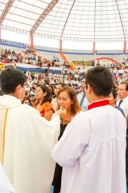 Tumbes, Tumbes, Peru 21-10-2023, Onaylama Ayini: Bir rahip kalabalığın önünde bir kadını kutsuyor. Rahip beyaz bir bornoz giyiyor ve kadın siyah bir elbise giyiyor. Kalabalık töreni dikkatle izliyor.