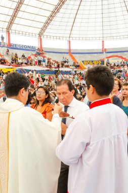 Tumbes, Tumbes, Peru 21-10-2023, Onaylama Ayini: Bir rahip beyaz cüppeli bir adamı kutsuyor. Rahip beyaz bir bornoz ve kırmızı bir haç giyiyor.