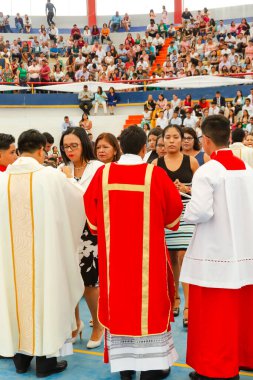 Tumbes, Tumbes, Peru 21-10-2023, Doğrulama Ayini: Bir rahip beyaz elbiseli bir kadını kutsuyor. Rahip kırmızı bir bornoz giyiyor ve kadın beyaz bir elbise giyiyor.
