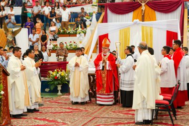 Tumbes, Tumbes, Peru 21-10-2023, Onaylama Töreni: Bir grup rahip, beyaz bir nesne tutan kırmızı cüppeli bir adamla masanın etrafında toplandı.