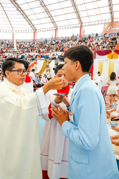 Tumbes, Tumbes, Peru 21-10-2023, Onaylama Ayini: bir rahip bir çocuğu kutsuyor. Çocuk mavi bir takım elbise giyiyor. Rahip beyaz bir bornoz giyiyor.