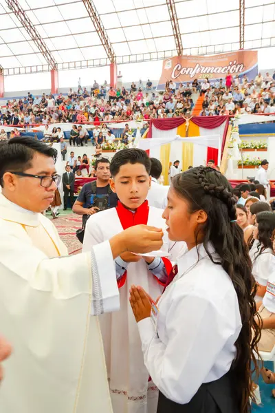 Tumbes, Tumbes, Peru 21-10-2023, Onaylama Ayini: bir rahip bir kızı kutsuyor. Kız beyaz bir gömlek giyiyor.