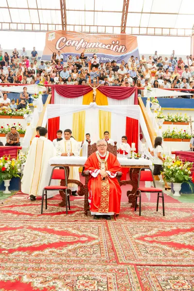 Tumbes, Tumbes, Peru 21-10-2023, Onaylama Ayini: Kırmızı cüppeli bir rahip ve bir adam masada oturuyor.