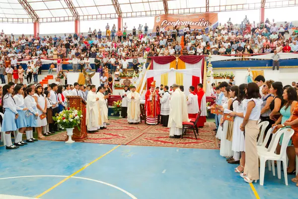 Tumbes, Tumbes, Peru 21-10-2023, Ayin Ayini: Dinsel bir tören için stadyumda büyük bir kalabalık toplandı. Etkinlik bir rahip ve bir grup genç tarafından yönetiliyor.