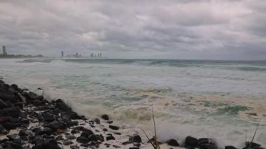 Küçük fırtına dalgaları ve dalgalar, Avustralya 'daki Gold Coast' a çarpan eski bir kasırganın ardından tehdit altındaki Sörfçüler Cenneti şehriyle birlikte sahile doğru ilerliyor..