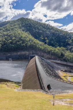 Avustralya, Queensland 'daki Mary Valley Sulama Projesi' nde Borumba baraj gölünün suyunu tutan bir baraj duvarı. Arkaplanı orman tepesi ve bulutlu bir gökyüzü.. 
