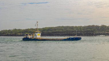 Yüklü bir zıpzıp mavnası, Queensland, Avustralya 'daki Gold Coast Seaway' e okyanustan kumu taramak için deniz yoluyla denize açılır..