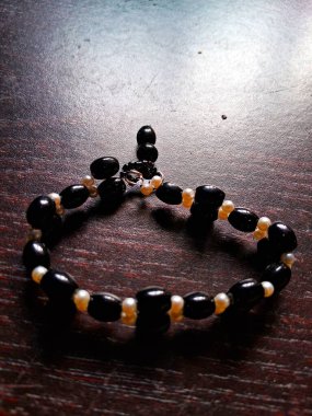 Taşın üzerinde siyah beyaz bir kolye.