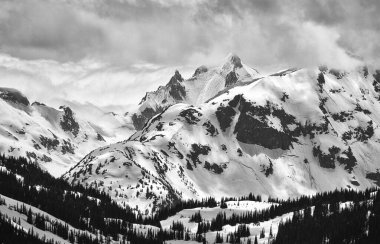 Kış boyunca Kanada kıyı dağlarında siyah ve beyaz zirveler ve bulutlar.