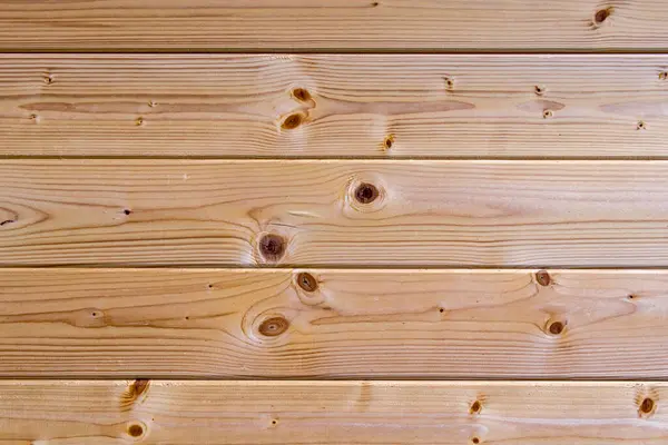 Görünür düğümleri ve tahıl çizgileri olan doğal ahşap tahtalar, yumuşak ışıkta fotoğraflanmış. Doku geçmişi, ürün modellemeleri veya rustik tasarım temaları için ideal.