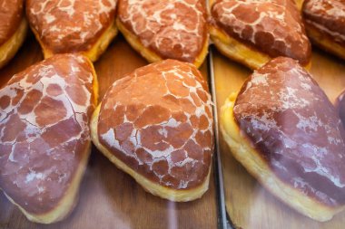 Tahta tepsilerde taze jöleli çörekler. Çatlamış şeker kaplı geleneksel Polonya ponczki 'si servis edilmeye hazır..