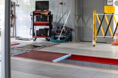 Araç gereçleri, teşhis araçları ve kırmızı platformlu modern araba servisi atölyesi. Temiz döşeme ve endüstriyel iç döşeme.