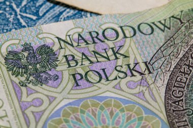 Polonya banknotunun ulusal amblem ve Narodowy Bank Polski metnini gösteren yakın çekimi. Maliye, para birimi ve ekonomik kimlik kavramı.