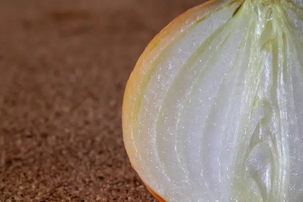 Dilimlenmiş soğanın yakın plan görüntüsü, sulu dokusu ve ışıldayan yüzeyi. Tazelik ve organik katmanları vurgulayan kırpılmış bileşim.