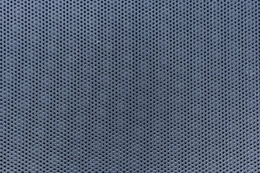 Eşit aralıklı yuvarlak delikleri olan metalik delikli bir levhanın yakın çekimi geometrik endüstriyel desen oluşturur..