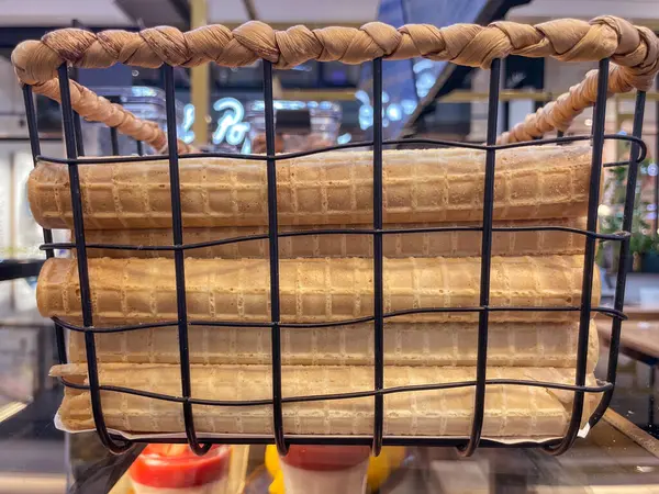 Dekoratif bir market sepetine istiflenmiş gözleme ruloları, bir perakende veya kafe ortamında rahat ve iştah açıcı bir görüntü oluşturur.