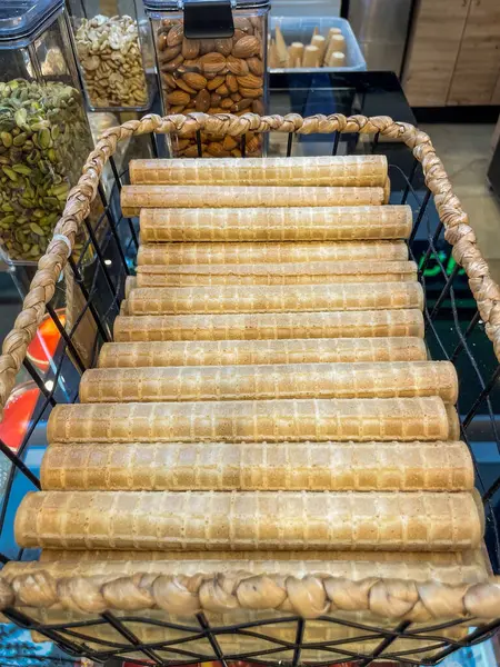 Gevrek gofretler arka planda fındık ve tohum kavanozları olan bir market sepetinde güzelce istiflenir. Yemek ve atıştırmalık kavramları için mükemmeldir..