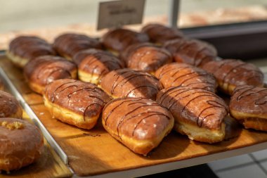 Pastanedeki ahşap tepside birçok çikolatalı kruvasan sergileniyordu. Doğal ışıkta çikolata serpiştirilmiş tatlı pastalar..