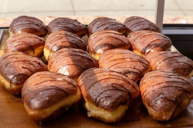 Çikolata serpiştirilmiş üçgen şekilli donutlar, doğal ışıkta ahşap tepside dizilmiş..