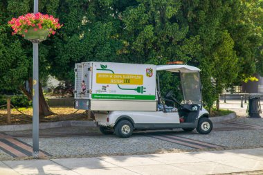 Wroclaw.Poland. 10.04.2025 Elektrik servis aracı. 100 elektrik var, yeşil ağaçların önündeki kaldırımlı bir caddede park halindeyim..