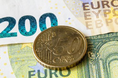 200 avroluk banknota 50 avroluk bozuk para yakın plan. Macro, AB para birimi, dokular ve çağdaş Avrupa parasının ayrıntılarını gözler önüne serdi.