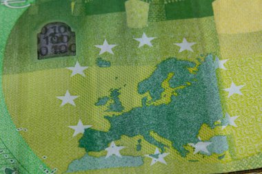 Avrupa haritası, yıldızlar ve güvenlik özelliklerini gösteren 100 avroluk banknotun Macro fotoğrafı. Canlı renkler ve ayrıntılı doku AB para birimi tasarımını vurguluyor.