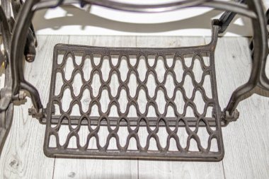 Hafif ahşap zeminde geometrik desenli klasik metal koltuk ayaklığı. ev 