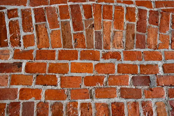 Yıpranmış dokusu ve beyaz havan topuyla eski kırmızı tuğladan bir duvara yakın plan, arka plan veya mimari kavramlar için mükemmel..