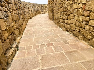 Mdina, Malta 'da altın kireçtaşı duvarlarla kaplı eğri bir yol. Dar geçit ve ılık tonlar zamansızlık ve Akdeniz cazibesini çağrıştırıyor..