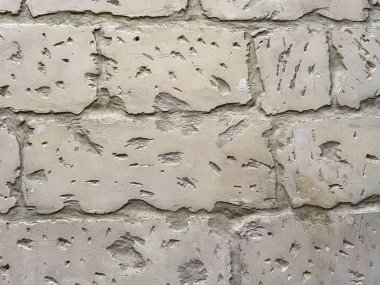Close-up of aged limestone wall with visible erosion, cracks and chisel marks. Natural textured background from historic building in Malta.