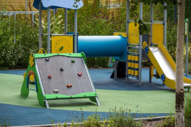 Modern bir açık hava parkında duvarları, kaydırakları, tünelleri ve yumuşak döşemeleri olan renkli çocuklar için oyun alanı.