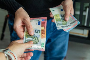 Avro banknotlarını değiş tokuş eden iki kişinin yakın çekimi. Bireyler arasında ödeme, işlem, mali anlaşma veya para değişimi kavramı.