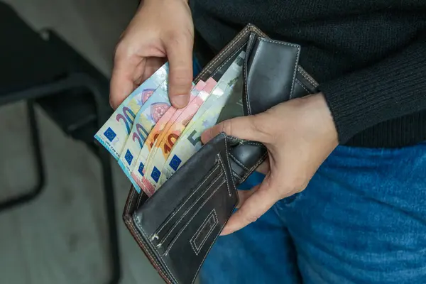 Elinde euro banknotları olan açık cüzdanlı bir kadın. Kişisel finans, harcama, bütçe, tasarruf ve ekonomik yaşam tarzı kavramı.