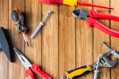 Tornavida, pense, ingiliz anahtarı, çekiç ve tahta arka planda vidalar gibi el aletleri. Üst Manzara. Ev onarımı ve DIY araçları kavramı.