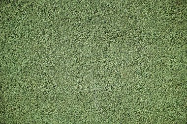 Oyun parkında güvenli döşeme olarak kullanılan yumuşak kauçuk granül yüzeyine yakın çekim. Şok edici, çocuk dostu açık hava malzemesi. Üst görünüm.