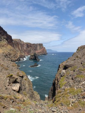 Dikey fotoğraf Madeira adasına kurulmuş resim koyunu yakalar. Körfez, güçlü okyanus dalgalarının büyük kayalara çarptığı yüksek ve kayalık bir kıyı şeridine sahiptir. Seyahat kavramı