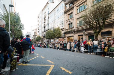 Santiago de Compostela, İspanya, 4 Mart 2025: İnsanlar Santiago de Compostela sokaklarını diziyor, İspanya, bir karnaval geçit töreninin canlı atmosferinin keyfini çıkarıyorlar
